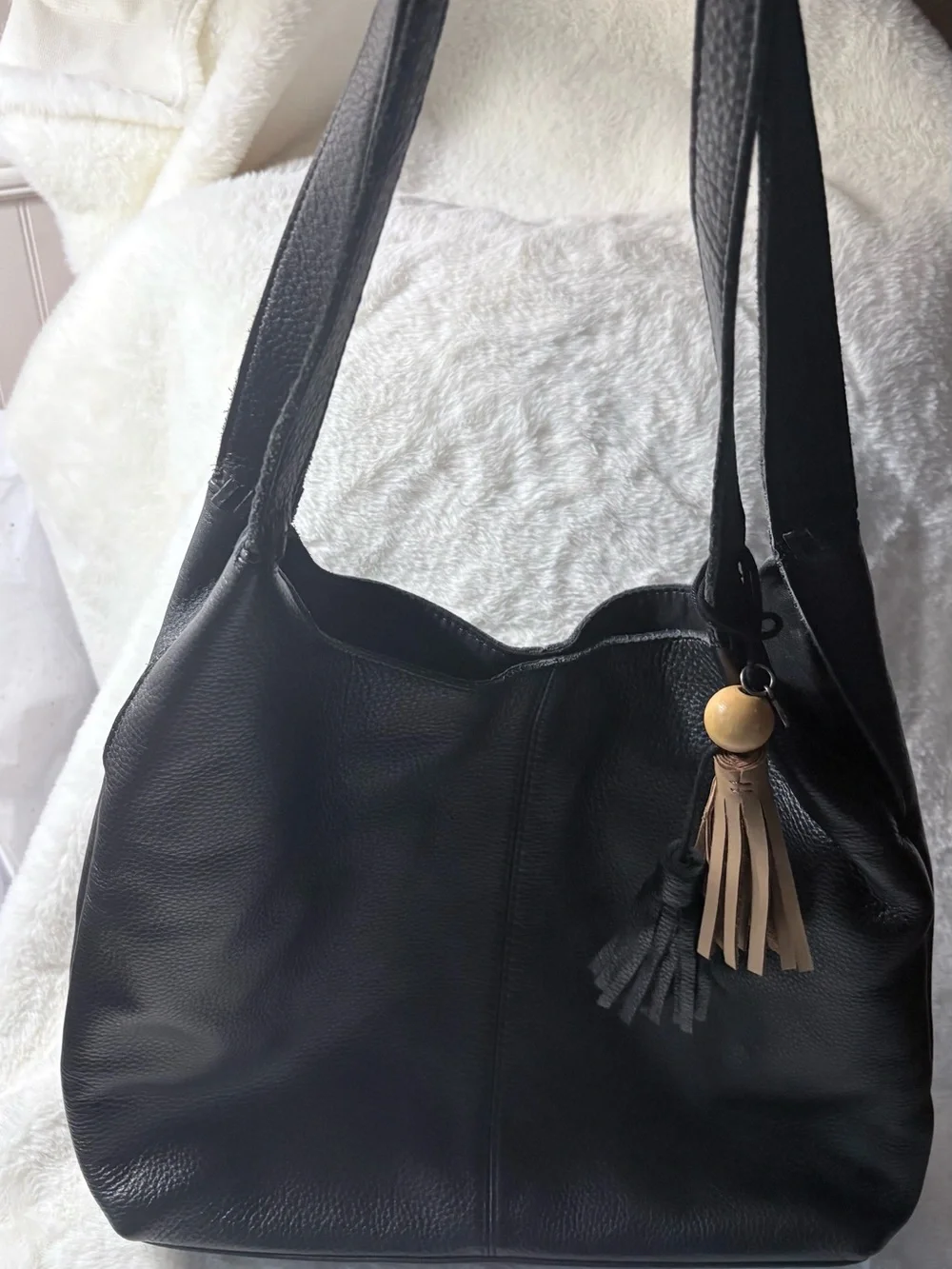 The Sak Black Leather Shoulder Bag with Tan Tassel Charm